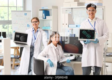 Scientific research and medical innovation, diverse team of young scientists working with digital data and laboratory technology in a modern facility Stock Photo