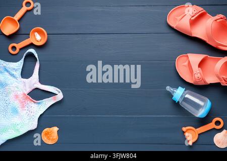 Summer vacation and family travel, beach accessories with baby items on dark wooden background for holiday planning and parenting lifestyle Stock Photo
