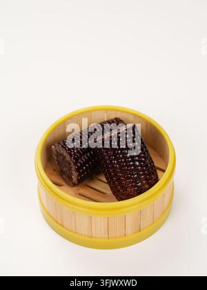 Two Black Purple Corn Segments in Yellow Rim Bamboo Steamer Stock Photo