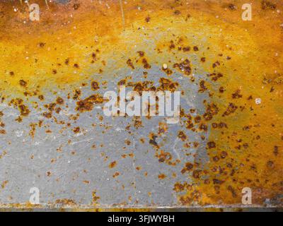 Rusty metal surface. Old paint and corrosion spots are visible. Yellow, brown, red colors of corrosion. Stock Photo