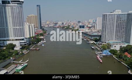 BANGKOK, THAILAND - MAR 15, 2026: An aerial view of the Chao Phraya River winding through the cityscape of Bangkok, Thailand, with skyscrapers and boa Stock Photo