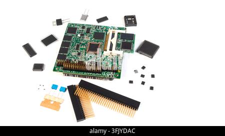 Various electronic components are scattered around a circuit board on a white surface. This scene shows a tech-related project in progress. Stock Photo