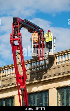 Workers using a mobile elevated work platform to carry out maintenance at Belton House, Lincolnshire, England. Stock Photo