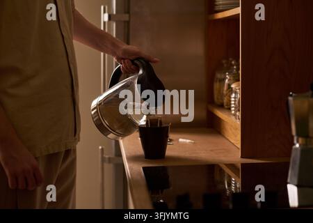 Man Pouring Hot Water from Kettle into Drip Coffee Cup Stock Photo