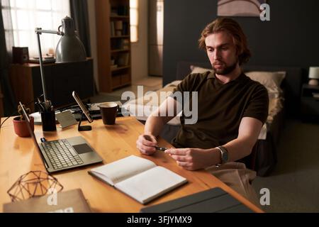 Focused Man Planning Daily Schedule and Working from Home Stock Photo