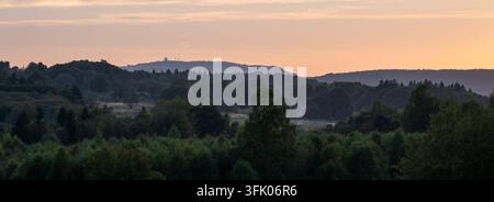 Golden hour glow over the Rh?n hills and Wasserkuppe with layered forest silhouettes, ideal for travel and nature use. Stock Photo