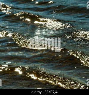 Bright sunlight glitters on rippling waves Stock Photo