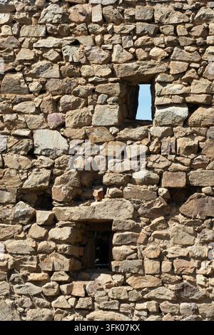 Old textured masonry wall featuring two windows Stock Photo