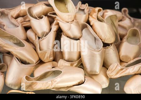 Numerous satin ballet pointe shoes piled up, symbolizing effort and passion for dance Stock Photo