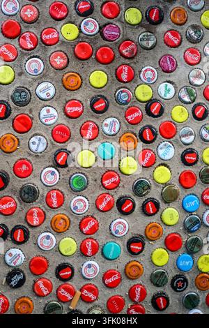 Berlin, Germany - 03. October 2024: Decorative mosaic made of various bottle caps embedded in concrete, adding a touch of urban art to Berlin Stock Photo