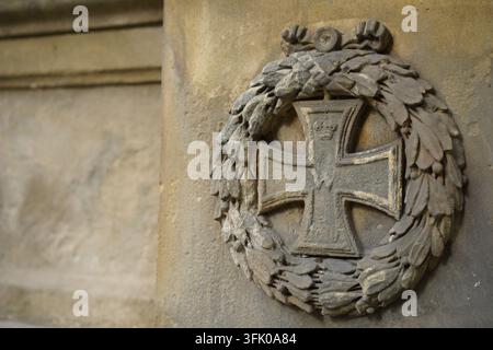 Close-up of a historic stone relief of an Iron Cross at the war memorial from 1890 i(Kriegerdenkmal) n Bernau near Berlin, Brandenburg, Germany. Stock Photo