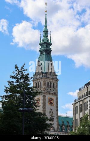 Hamburg, Germany - 23. August 2025: The impressive tower of Hamburg Rathaus stands tall against a backdrop of blue sky and white clouds Stock Photo