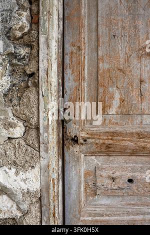 Old weathered wooden door with a padlock showing texture and signs of age Stock Photo