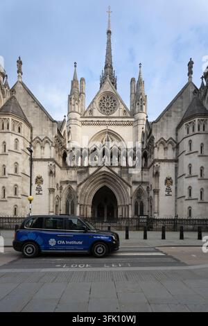 A CFA Institute branded taxi drives past the Royal Courts of Justice on Strand in London for urban transit and mobile advertising. Stock Photo