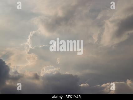 a dramatic, multi-layered cloudscape bathed in a soft, ethereal glow. The composition beautifully captures the contrast between light and shadow. Spac Stock Photo
