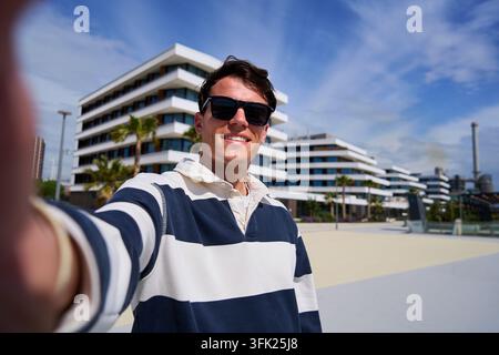 Young man taking selfie outdoors. Stock Photo