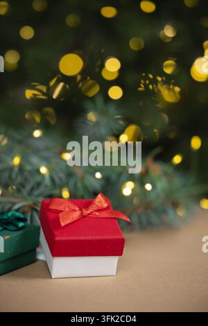 Red Christmas Gift Box with Bow and Golden Bokeh Lights Stock Photo