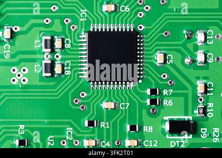 Green electronic circuit board with microchip. Technology background for electronics engineering components hardware computing and digital systems. Stock Photo