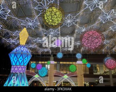 Vibrant geometric light installations featuring illuminated spheres and decorative elements suspended from a ceiling. The display showcases blue, yell Stock Photo