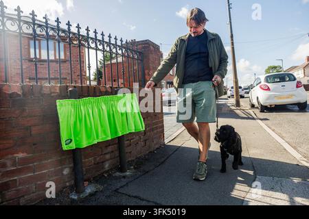 EDITORIAL USE ONLY Paul Tompkins and his dog Belle react to a green velvet curtain which covers the Bell End road sign in Rowley Regis as part of an Asda Money campaign launched following research suggesting many drivers have been distracted by unusual road and place names. Issue date: Wednesday September 23, 2026. Stock Photo