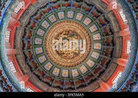 Close-up low angle view of gilded coiled dragon caisson ceiling inside a pavilion at the Forbidden City Stock Photo