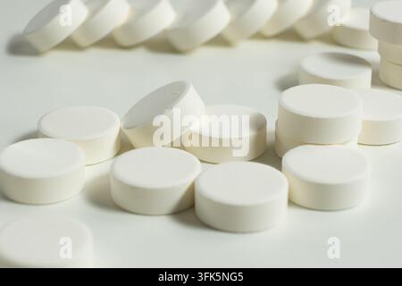 Macro shot of white effervescent tablets on white surface. Stock Photo