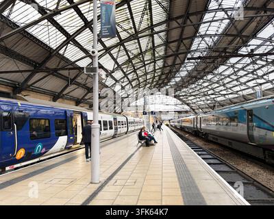 Liverpool, UK - May 16, 2026: Passengers wait on a spacious platform at Lime Street station in Liverpool as regional and intercity trains prepare to d Stock Photo