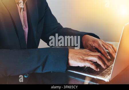 Close up of a businessman’s hands typing on a laptop in a professional setting. Stock Photo