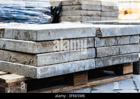 Stacked concrete paving slabs on wooden pallet ready for walkway and patio installation Stock Photo