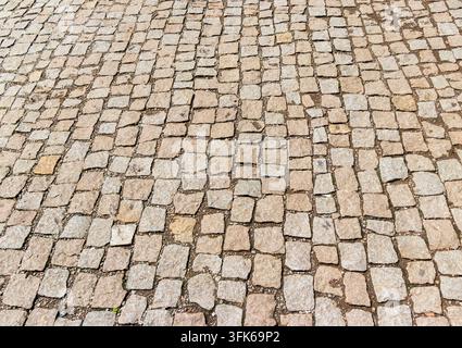 High angle perspective view of an old cobblestone street paved with natural stone blocks. Stock Photo