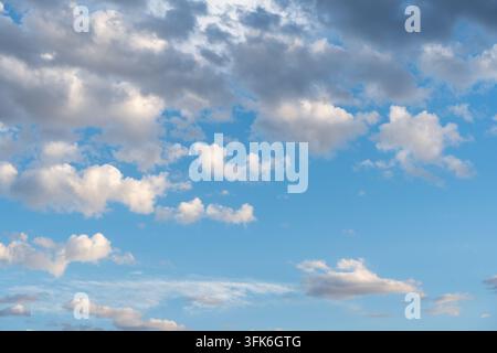 Summer blue sky dotted with gray and white cumulus clouds Stock Photo