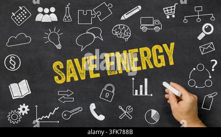 Save Energy written on a blackboard with icons Stock Photo