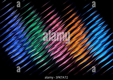 Abstract full frame photograph of diagonal vibrant neon light wave pattern shining through fluted corrugated glass on black background. Concept of sou Stock Photo