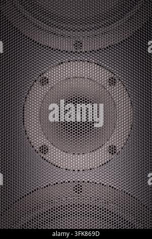 Close-up of a loudspeaker grille revealing the circular audio driver behind a fine metal mesh pattern. Stock Photo