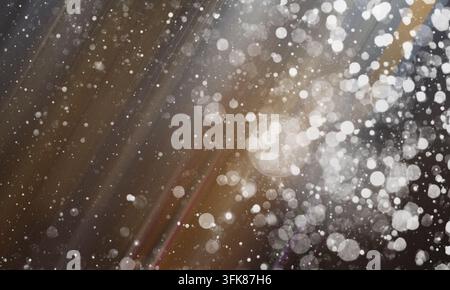 Abstract background with soft brown and grey tones, featuring glowing bokeh circles and subtle light streaks, perfect for creative design projects. Stock Photo