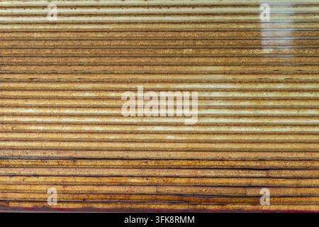 Rusty industrial metal shutter with horizontal lines. Stock Photo