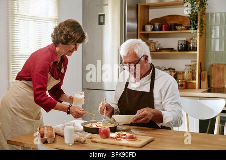 Elderly Couple Preparing Ingredients for Homemade Apple Pie Stock Photo