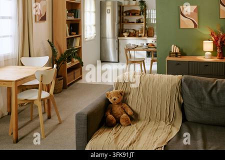 Teddy Bear Sitting on Sofa in Cozy Apartment Interior for Family Lifestyle Stock Photo
