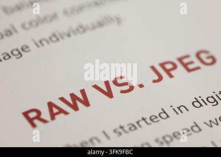 Explaining raw versus jpeg file formats in digital photography, text on paper with focus on comparison concept Stock Photo