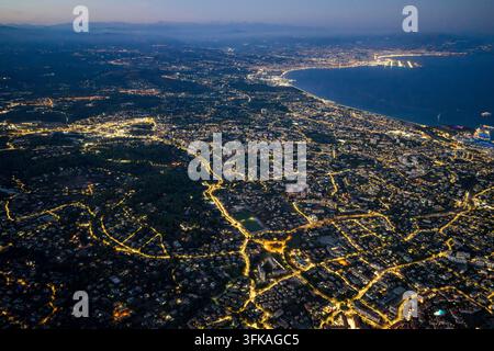 Aerial view of the illuminated city of Antibes at night, showing ...