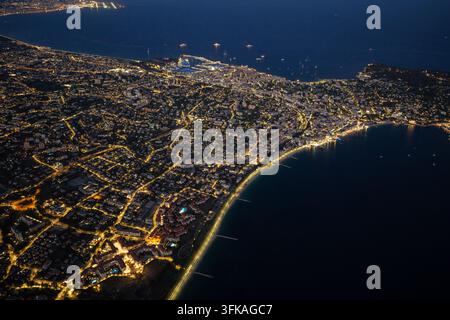 Aerial view of the illuminated city of Antibes at night, showing ...