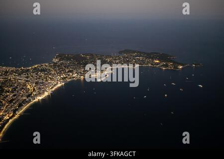 Aerial view of the illuminated city of Antibes at night, showing ...