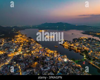Aerial view of the illuminated cityscape of Udaipur at night with ...