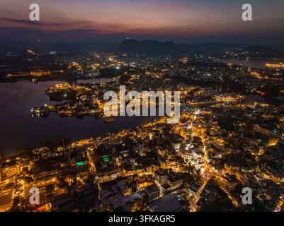 Aerial view of the illuminated cityscape of Udaipur at night with ...
