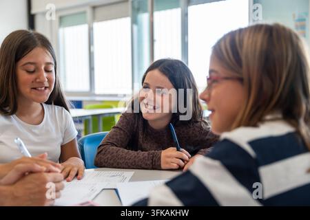 Elementary school girls learning and collaborating in classroom Stock Photo