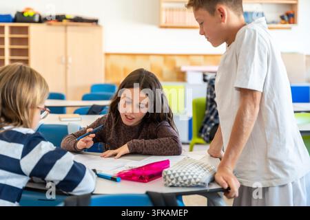 School children collaborating on a project in classroom Stock Photo