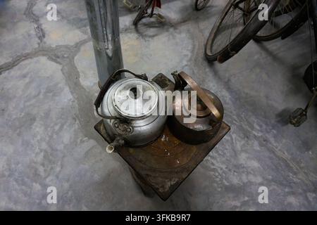 Aluminum kettle and copper kettle on old-fashioned cast iron coal stove Stock Photo