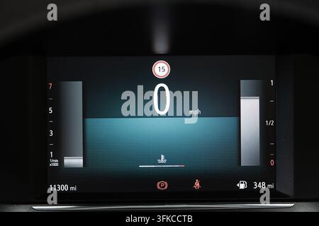 Close up view of a illuminated digital car instrument cluster screen showing zero mph, digital gauges, speed limit icon, mileage, and vehicle status i Stock Photo