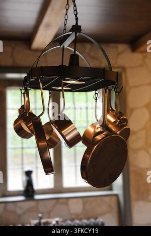 Vintage copper pans hanging from a centre beam Stock Photo