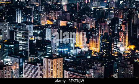 High-rise buildings overlook an illuminated street and a construction ...